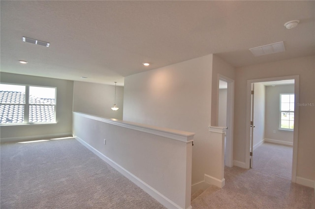 spare room featuring baseboards, visible vents, and light colored carpet