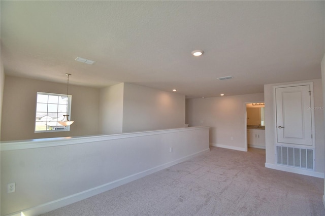 unfurnished room with recessed lighting, baseboards, light colored carpet, and visible vents