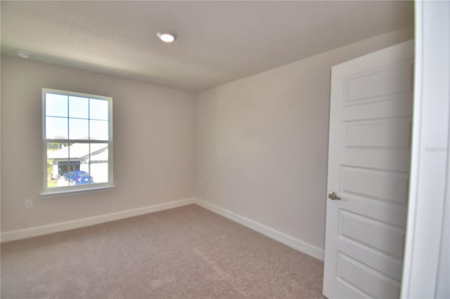 unfurnished room with baseboards and carpet