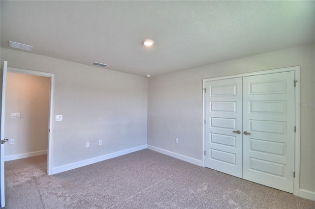 unfurnished bedroom with baseboards, visible vents, a closet, and carpet floors