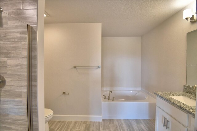 full bathroom featuring vanity, wood finished floors, a textured ceiling, a bath, and baseboards