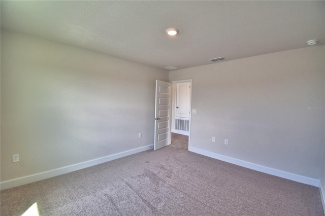 carpeted spare room with baseboards and visible vents