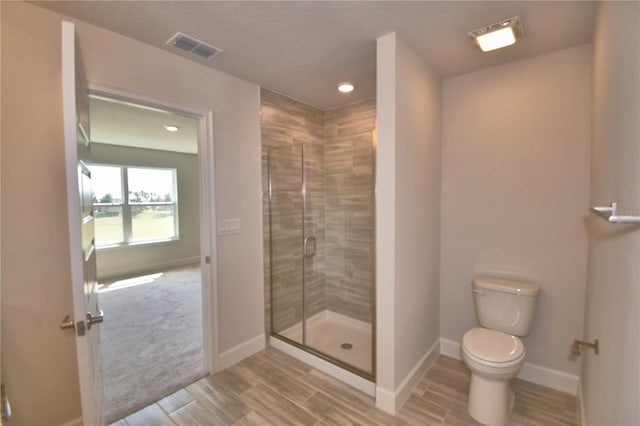 full bathroom featuring toilet, baseboards, a shower stall, visible vents, and wood tiled floor