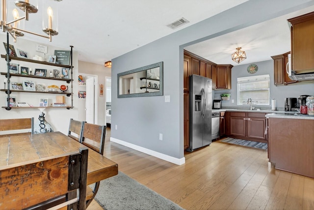 interior space with visible vents, light countertops, appliances with stainless steel finishes, and light wood finished floors