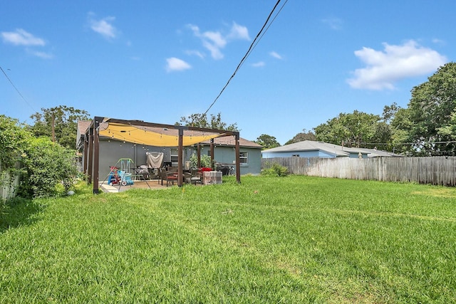 rear view of property featuring a patio, a yard, and fence