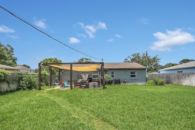 rear view of house featuring a fenced backyard, a yard, and a patio