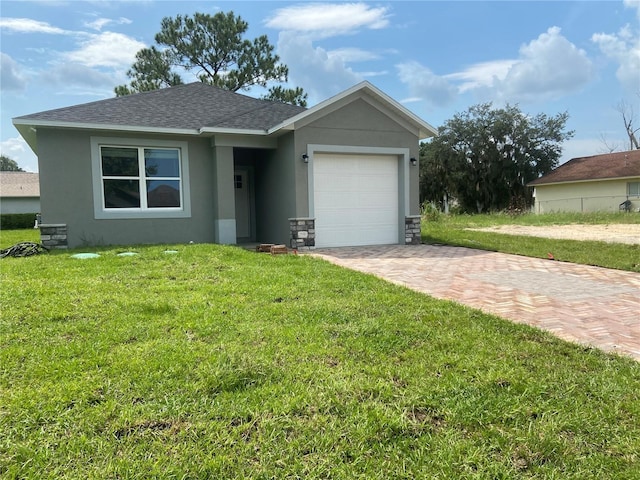 view of front of house with stucco siding, a front lawn, roof with shingles, and an attached garage