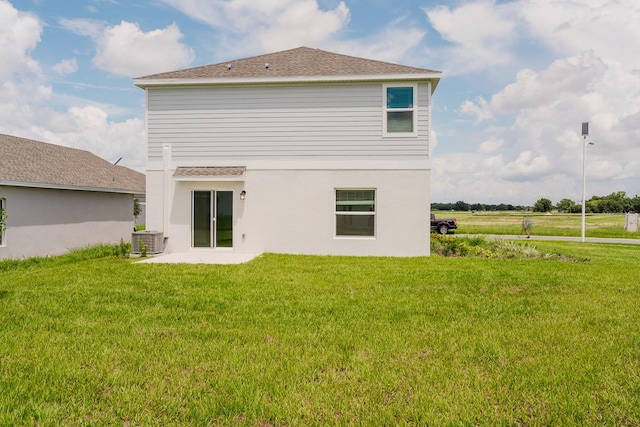 rear view of property with a patio, central AC, and a yard