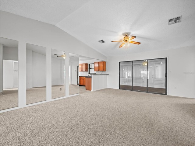 unfurnished living room with ceiling fan, light carpet, and lofted ceiling