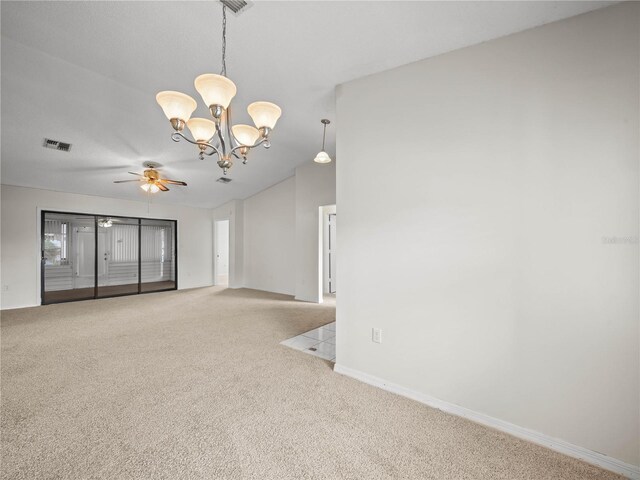 carpeted spare room with ceiling fan with notable chandelier