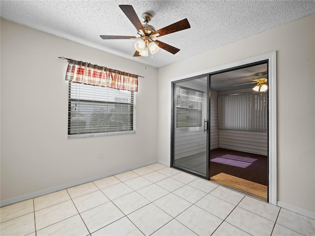 spare room featuring baseboards, a textured ceiling, and a ceiling fan