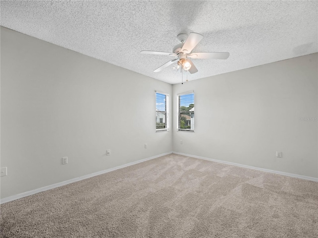 empty room featuring light carpet, baseboards, a textured ceiling, and ceiling fan