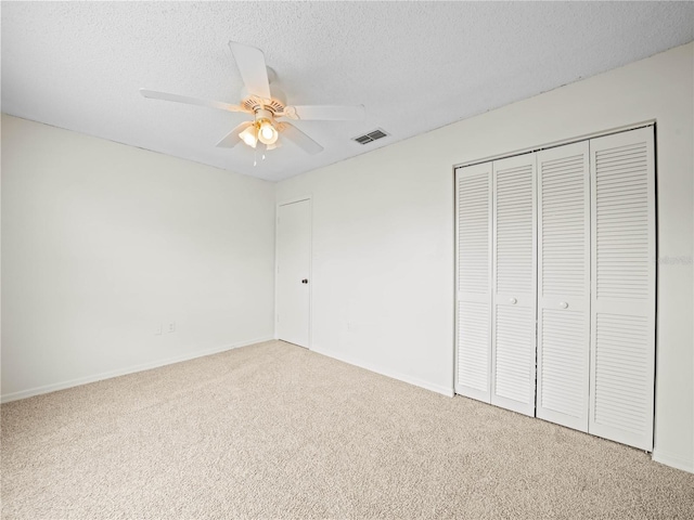 unfurnished bedroom with a ceiling fan, baseboards, carpet, visible vents, and a textured ceiling