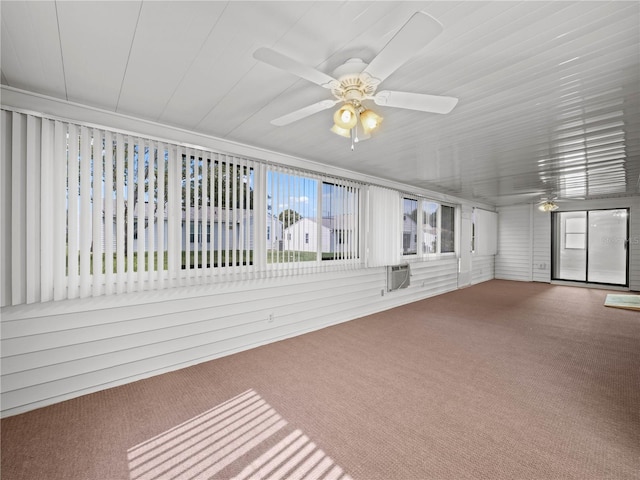 unfurnished sunroom featuring a wall mounted air conditioner and ceiling fan