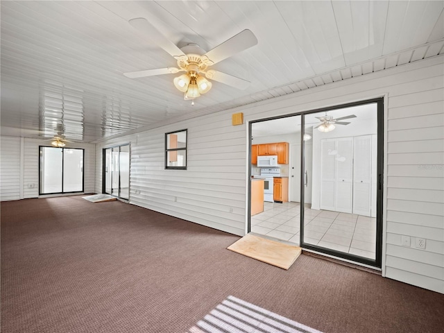 unfurnished sunroom featuring a ceiling fan