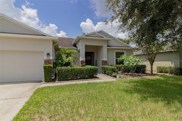 view of front of property with stone siding, an attached garage, a front lawn, and stucco siding