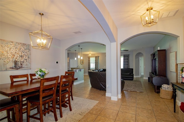 dining room featuring an inviting chandelier, light tile patterned floors, and baseboards