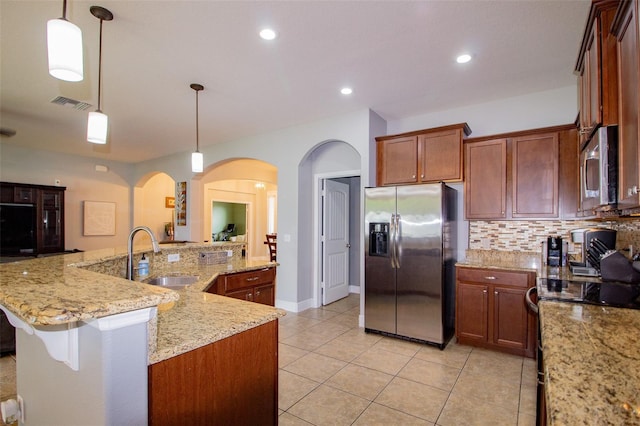 kitchen featuring decorative light fixtures, visible vents, decorative backsplash, appliances with stainless steel finishes, and a sink