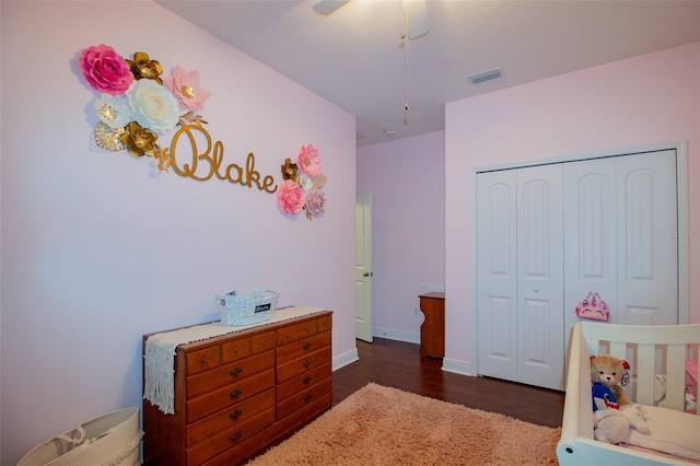 bedroom with baseboards, visible vents, dark wood-style floors, ceiling fan, and a closet