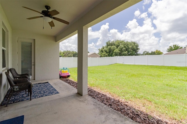 view of yard featuring a patio area, ceiling fan, and a fenced backyard