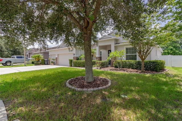 view of front of house with concrete driveway, an attached garage, fence, a front lawn, and stucco siding