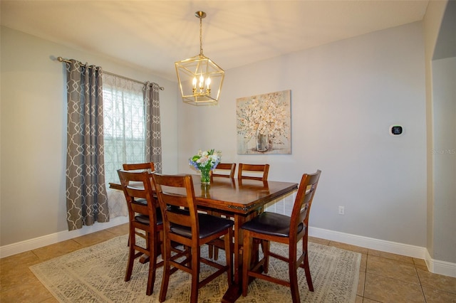 dining area with light tile patterned flooring, a notable chandelier, and baseboards