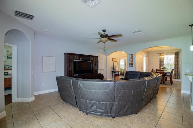 living room with light tile patterned floors, visible vents, and arched walkways