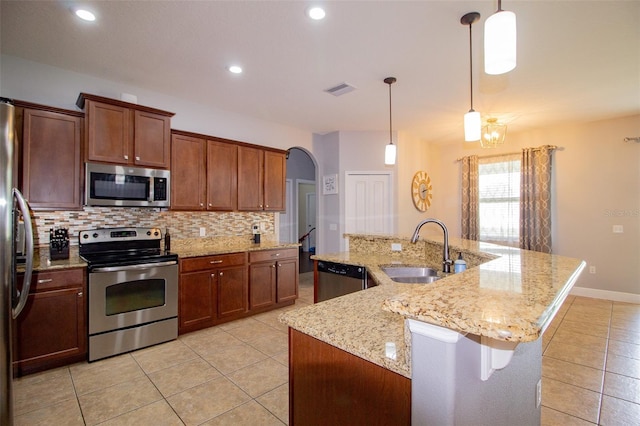 kitchen featuring arched walkways, a sink, visible vents, appliances with stainless steel finishes, and backsplash