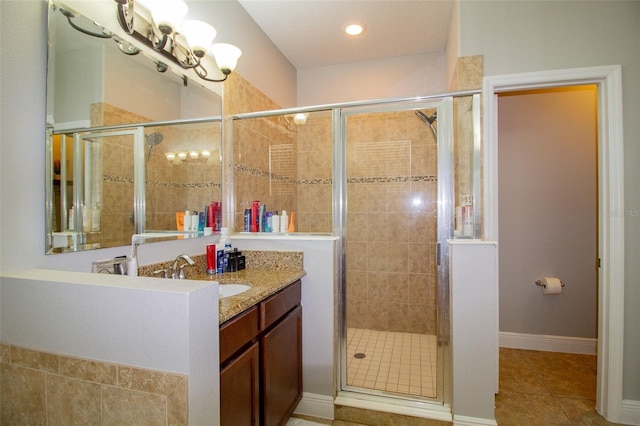 bathroom featuring a shower stall, vanity, baseboards, and tile patterned floors