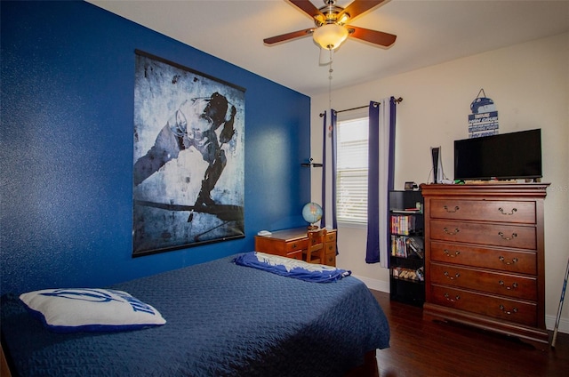 bedroom featuring ceiling fan, baseboards, and wood finished floors