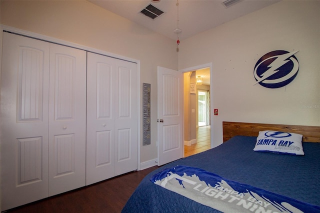 bedroom with a closet, visible vents, and wood finished floors