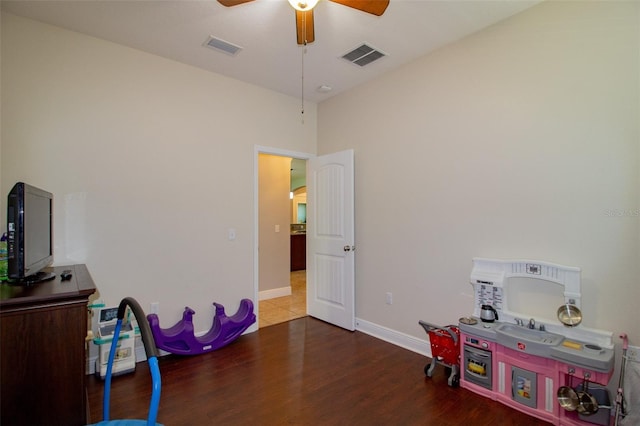 rec room featuring a ceiling fan, visible vents, baseboards, and wood finished floors