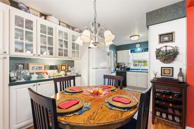 dining area with hardwood / wood-style floors and an inviting chandelier