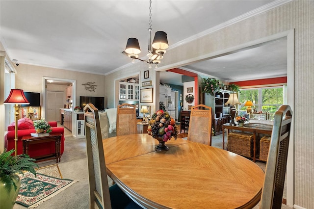 dining area featuring crown molding, a chandelier, and carpet floors