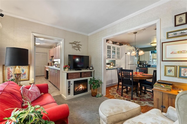 carpeted living room featuring crown molding and a chandelier