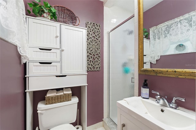 bathroom featuring walk in shower, toilet, and vanity