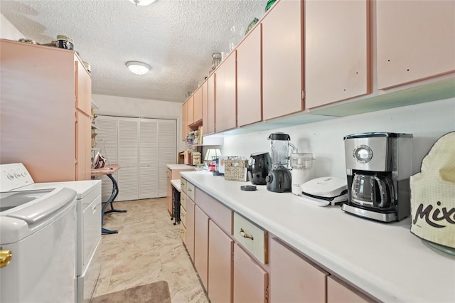 kitchen with a textured ceiling and washing machine and clothes dryer