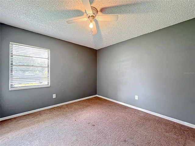 carpeted spare room with a ceiling fan, a textured ceiling, and baseboards