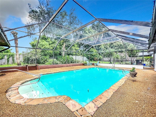 pool with glass enclosure and a fenced backyard