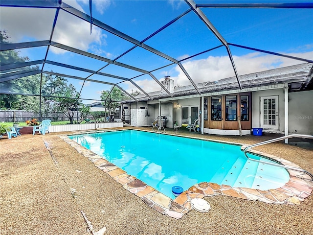 view of swimming pool with glass enclosure, a patio area, and a fenced in pool