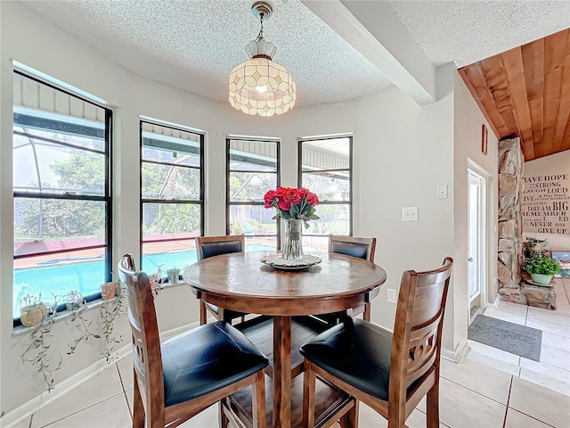 dining space with a healthy amount of sunlight, light tile patterned floors, and a textured ceiling