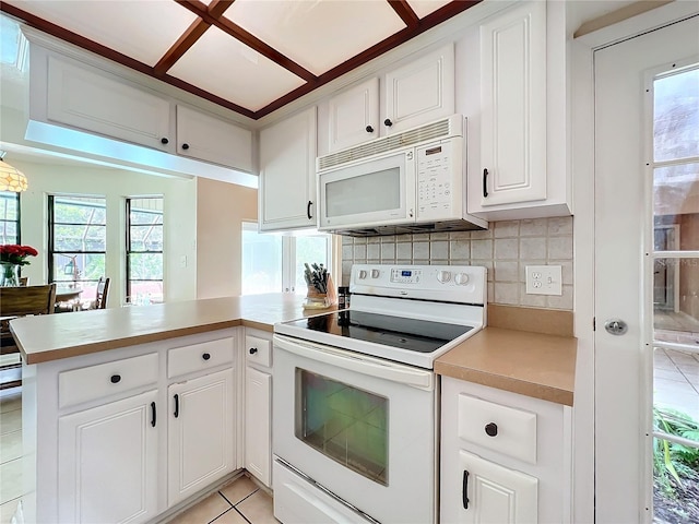 kitchen featuring a peninsula, white appliances, light countertops, and white cabinetry