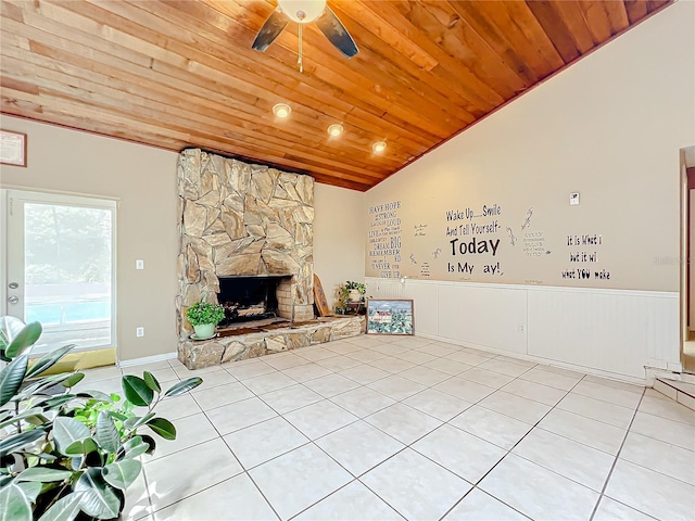 unfurnished living room featuring wooden ceiling, light tile patterned floors, vaulted ceiling, and a stone fireplace