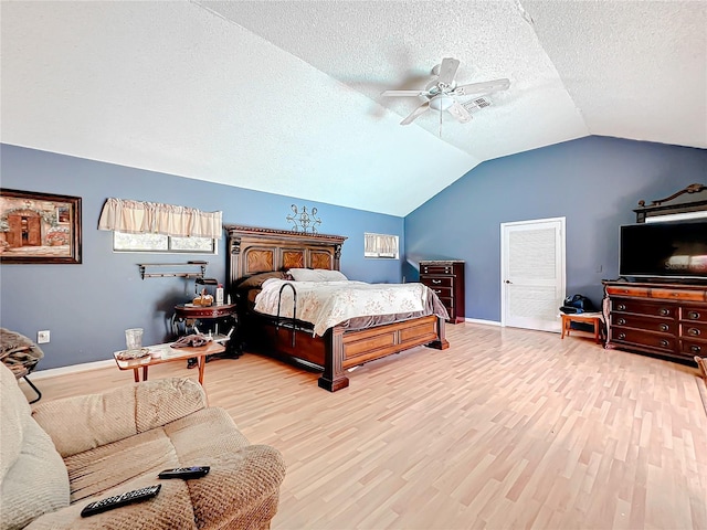 bedroom with light wood-type flooring, visible vents, a textured ceiling, and lofted ceiling