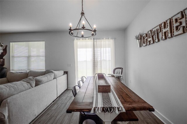 dining room featuring a notable chandelier, a wealth of natural light, and dark hardwood / wood-style floors