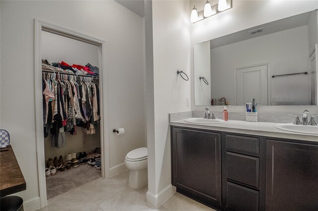 bathroom featuring double sink vanity, toilet, and tile patterned flooring