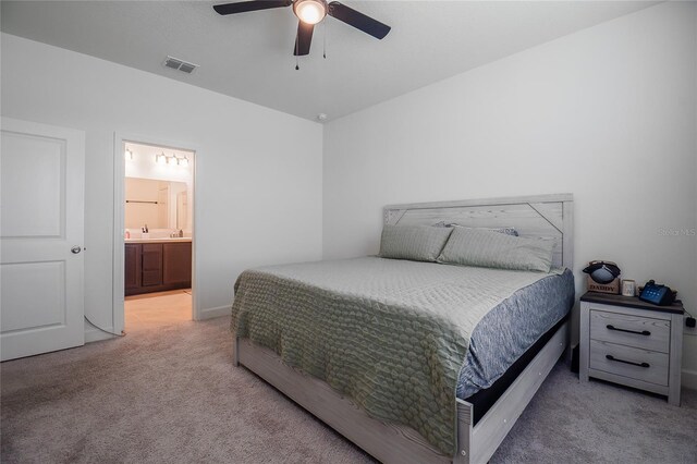 carpeted bedroom with ceiling fan and ensuite bathroom