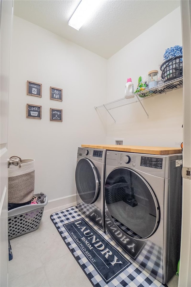 laundry room with tile patterned floors and washing machine and clothes dryer