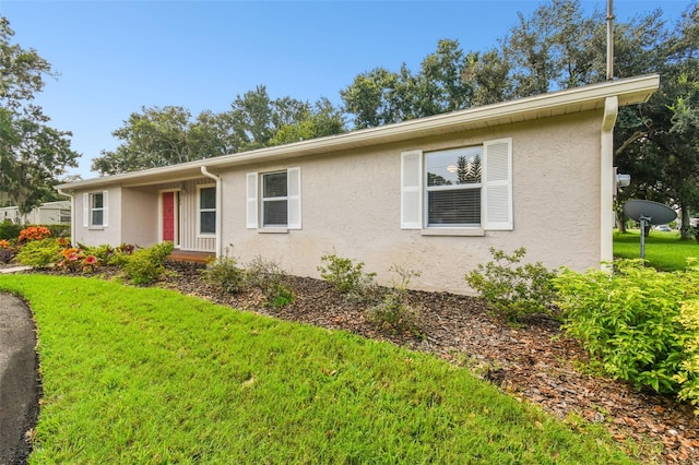 single story home featuring a front yard and stucco siding