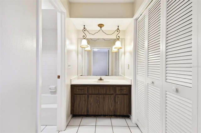 bathroom with a closet, vanity, and tile patterned floors